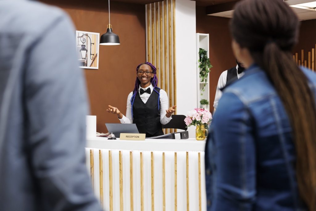 A receptionist greets customers with a smile